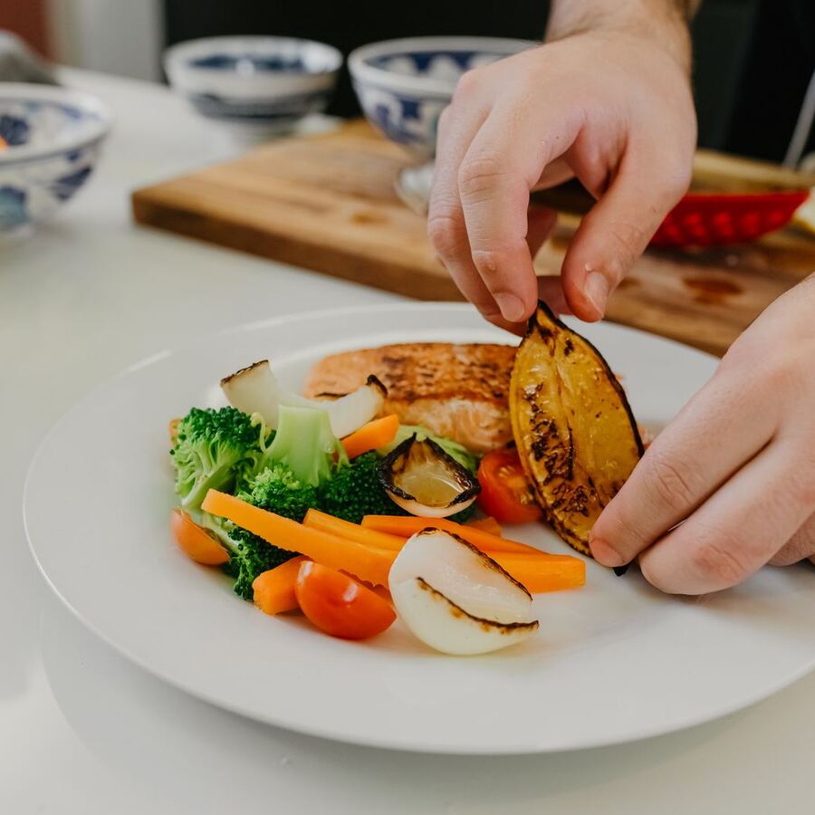 A chef finishing a plated dish